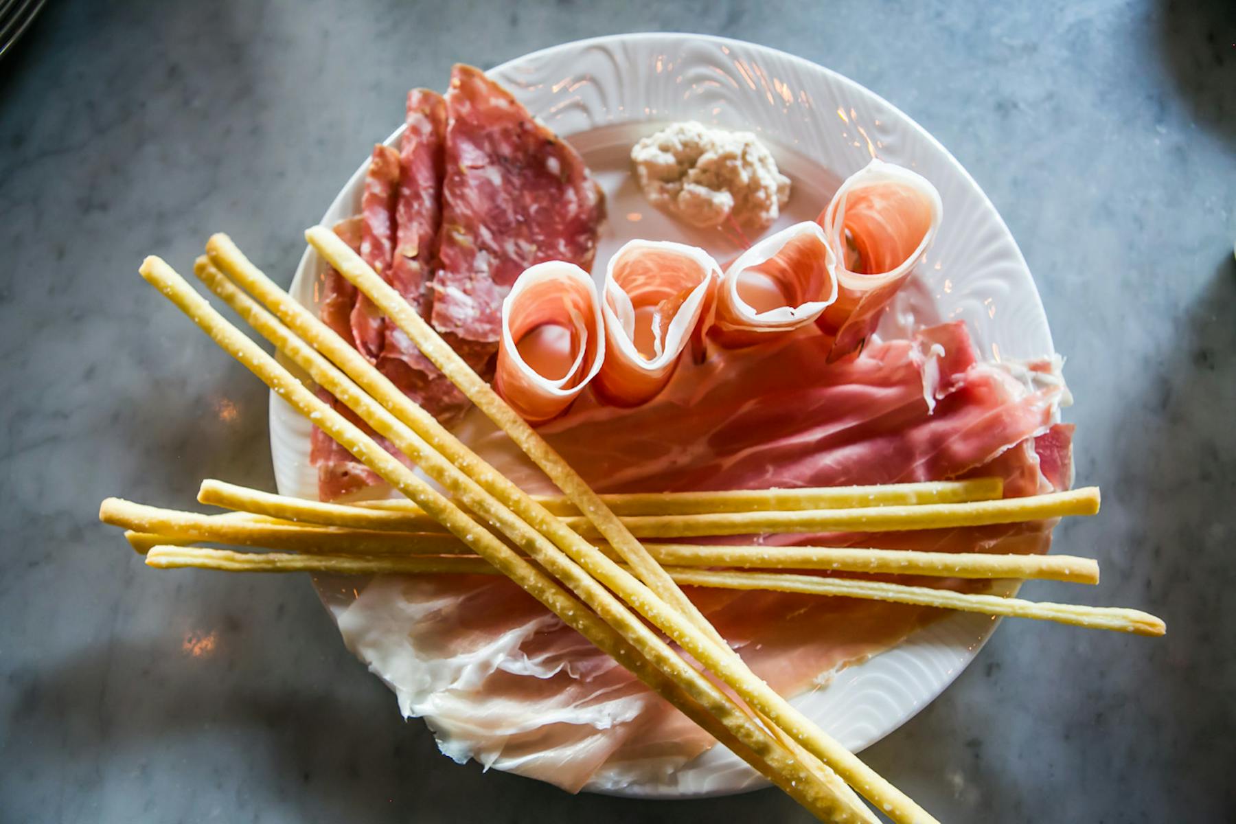 a close up of bread sticks and meat on a plate